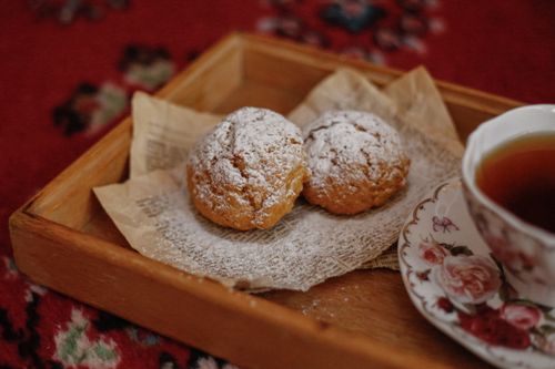 Free Delightful tea time setup with pastries sprinkled with powdered sugar on a wooden tray. Stock Photo