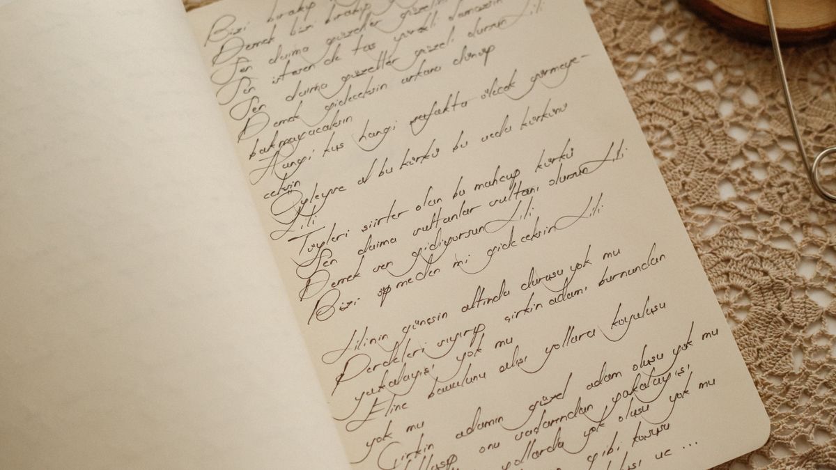 El yazısıyla Türkçe şiir yazılmış açık bir defter sayfası (temsilî görsel)
