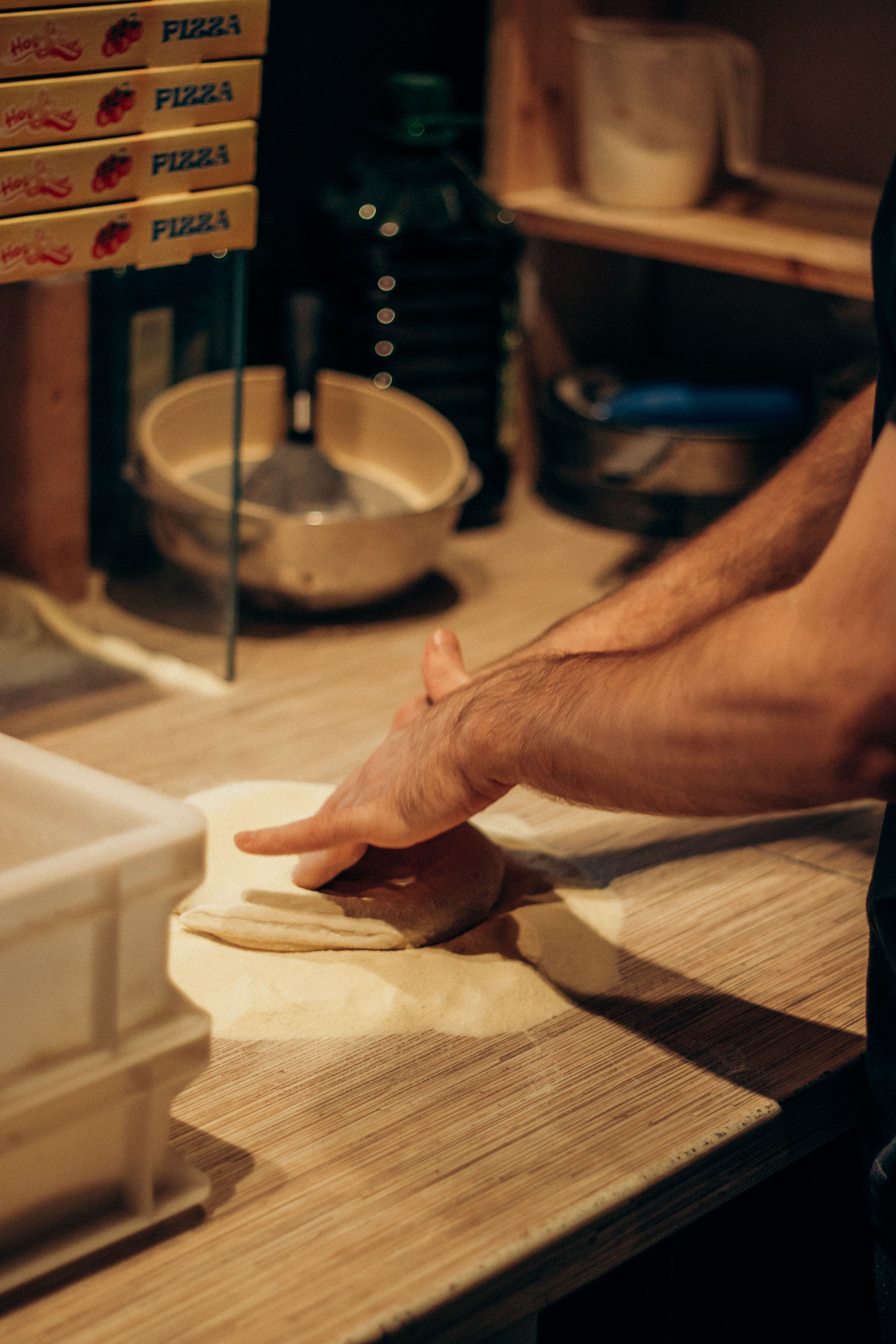 Fresh pizza dough ball on a floured wooden surface