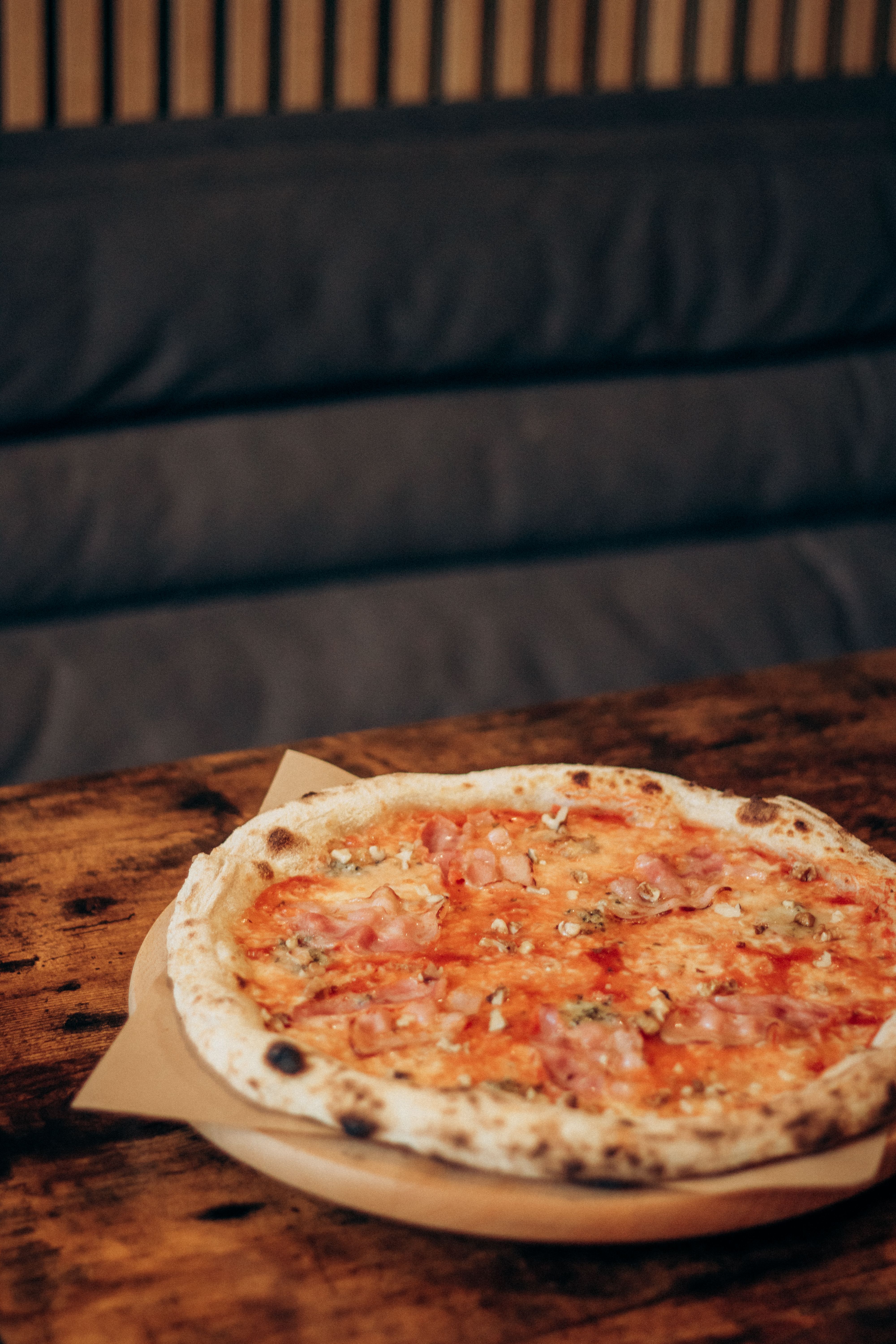 Delicious Neapolitan pizza with tomatoes and cheese on a rustic wooden table.