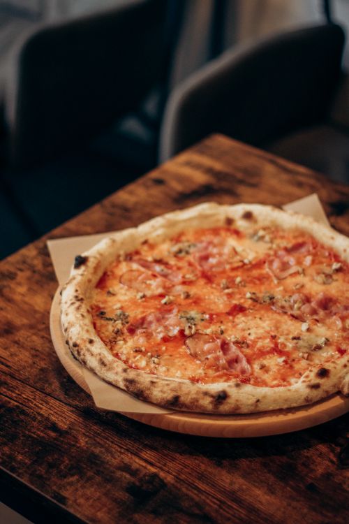 Free Wood-fired Margherita pizza on a rustic wooden table, ready to be served. Stock Photo