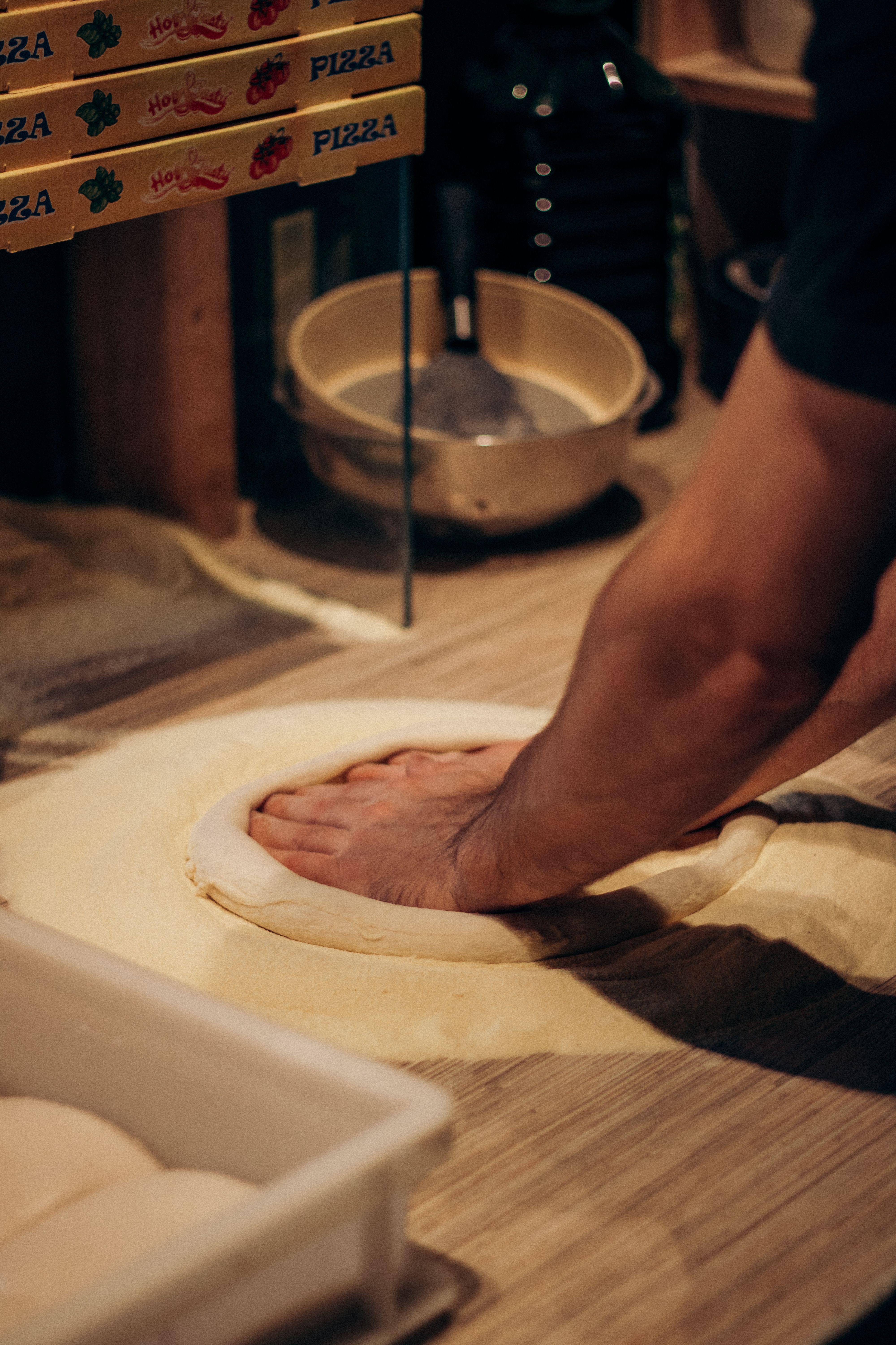 Préparation artisanale d'une pâte à pizza sur un plan de travail