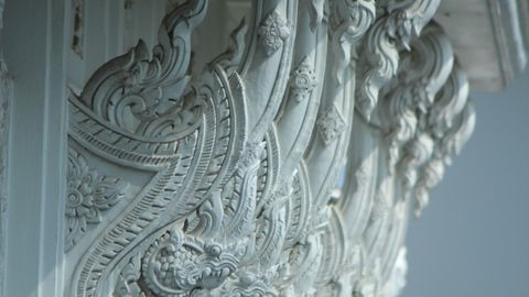 Close-up of carved architectural elements on a temple exterior showcasing traditional artistry.