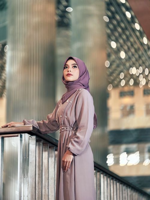 Free Stylish woman in hijab posing indoors with a blurred, bokeh-filled background. Stock Photo
