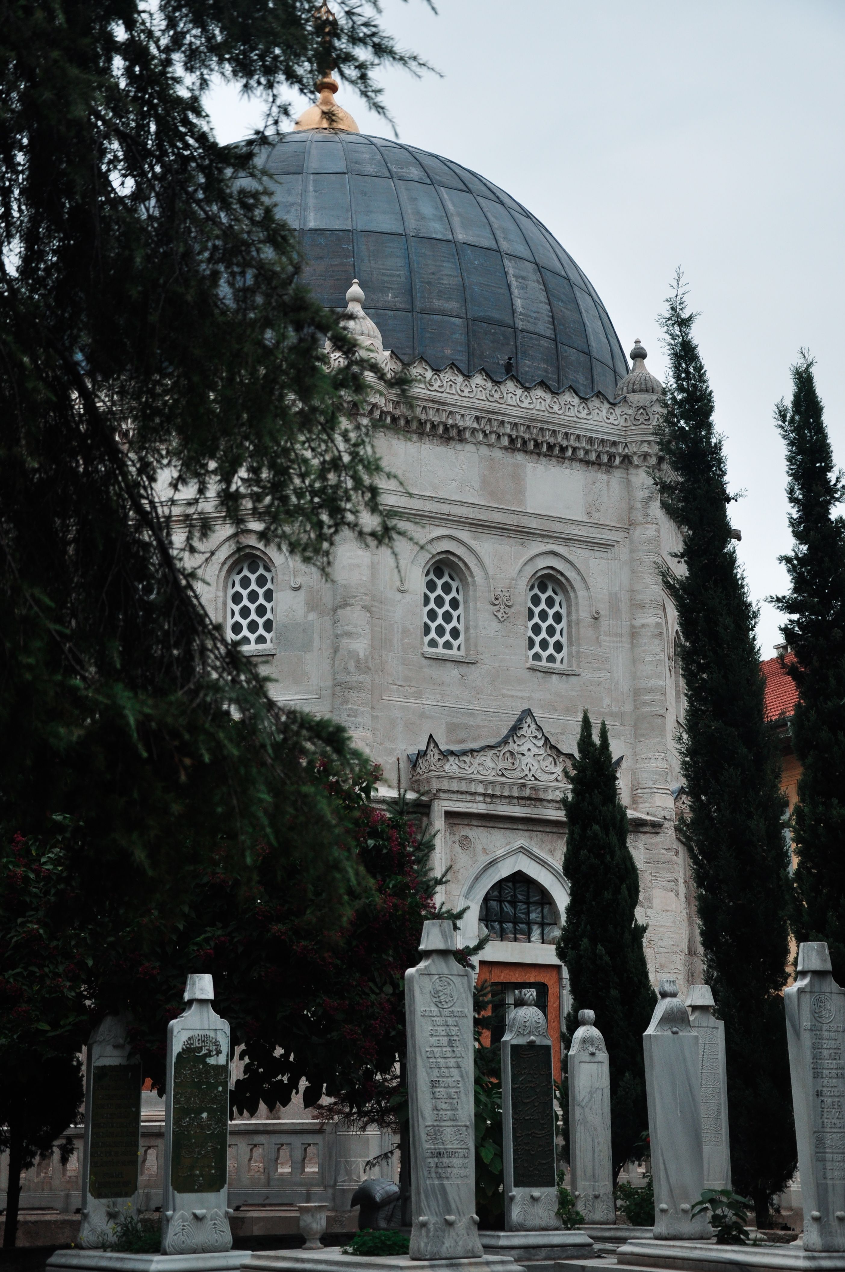 Elegant mausoleum surrounded by cypress trees, a serene historical site.
