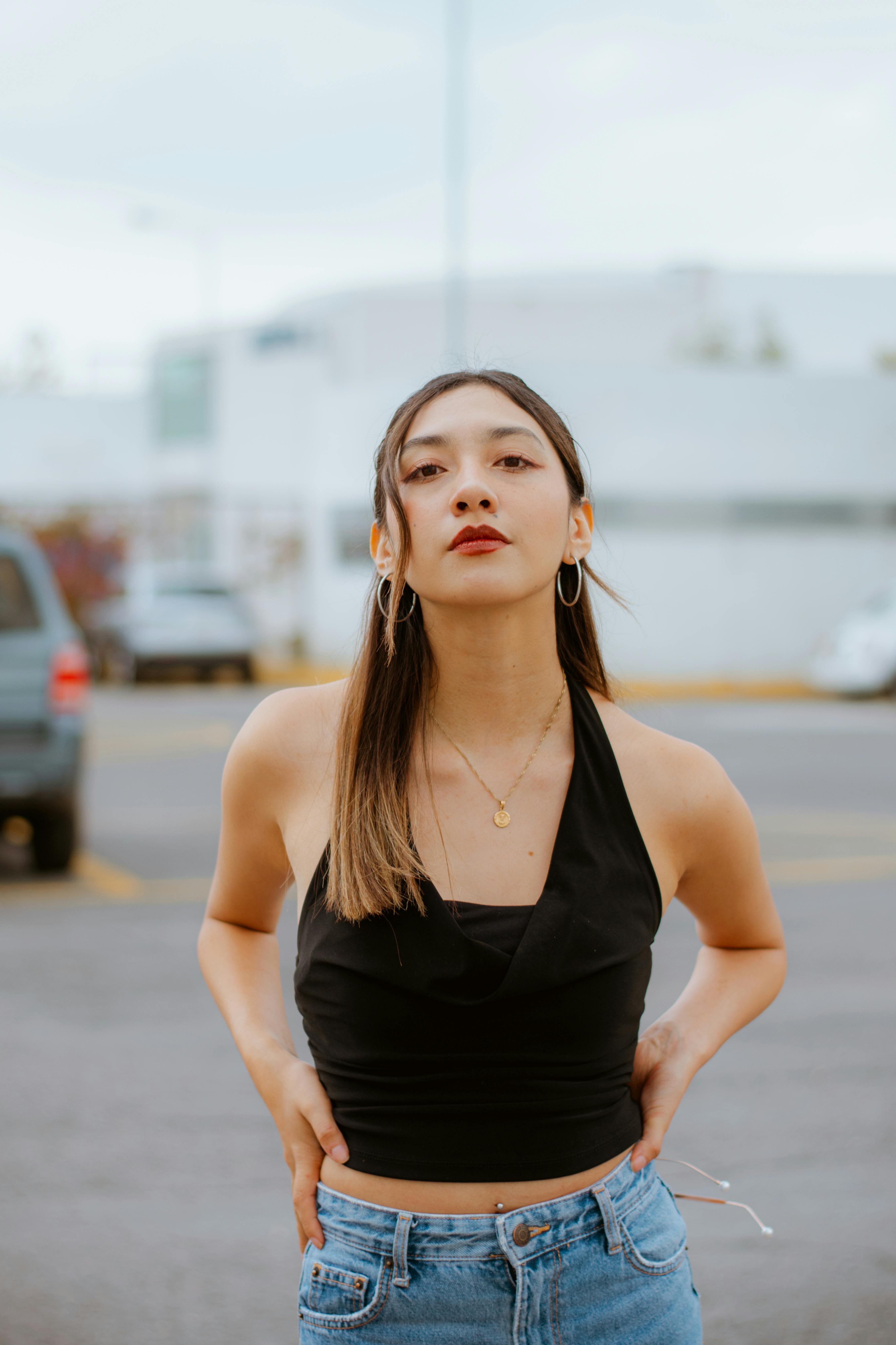 bezplatná Módní mladá žena sebevědomě pózuje venku a ztělesňuje moderní styl. Základová fotografie