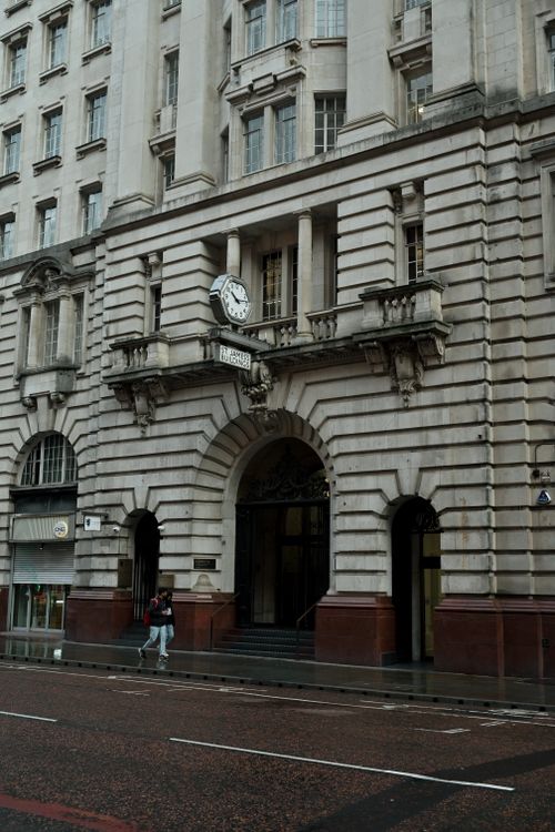 Free A classic European building facade featuring a large clock and arched entrance. Stock Photo