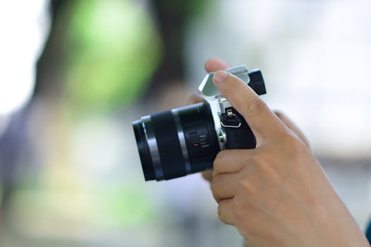 Detailed view of a person holding a camera in natural light, perfect for photography themes.