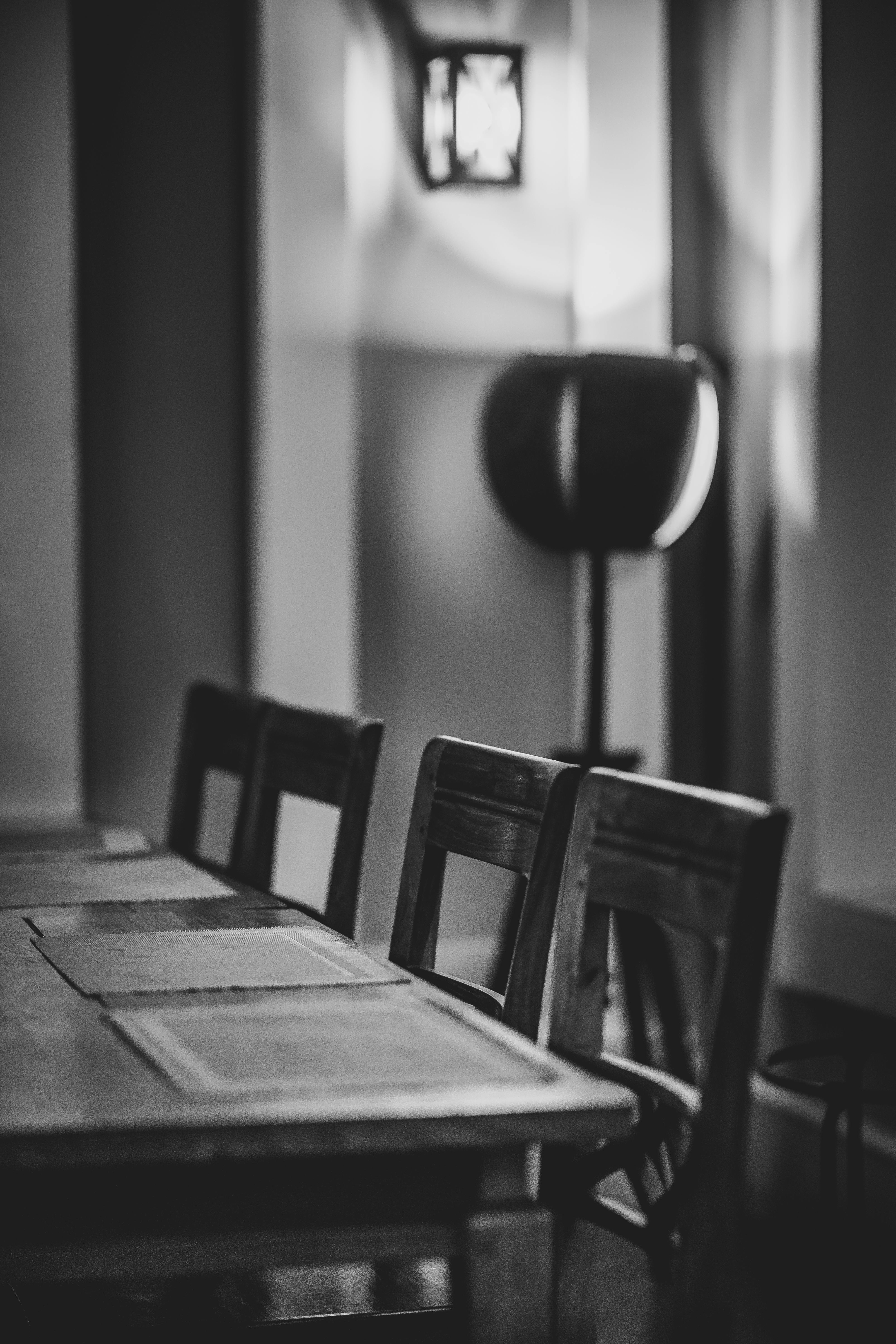 grátis Uma foto dramática em preto e branco do interior de um café vazio com móveis de madeira. Foto profissional