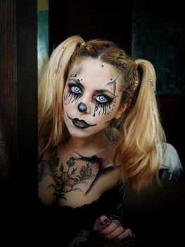 Close-up of a woman with intricate clown makeup and costume, perfect for Halloween or horror themes.