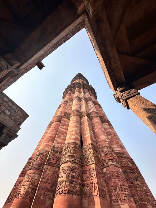 Free Stunning low angle shot of Qutub Minar, showcasing intricate Mughal architecture under a clear sky. Stock Photo