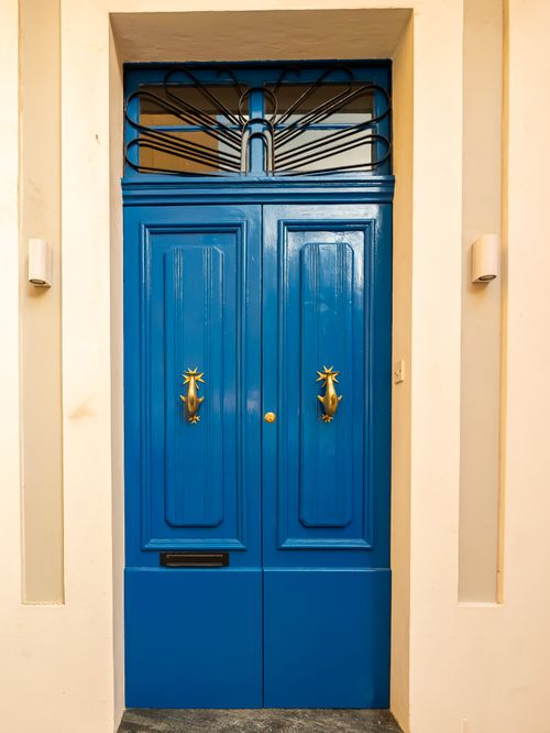 Free Stunning blue door with brass knockers, showcasing Mediterranean architecture style. Stock Photo