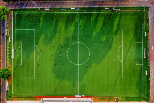 Free High-angle drone shot of a soccer field with players in Jakarta, Indonesia. Stock Photo