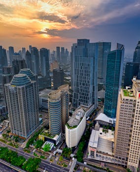 雅加达天际线的戏剧性日落，突显了其现代摩天大楼和城市景观