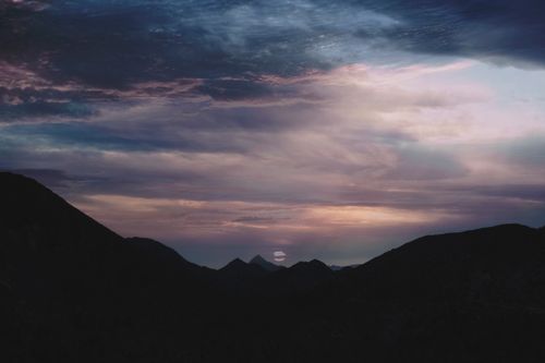 Free Serene twilight sky over mountains, capturing the transition from day to night. Stock Photo