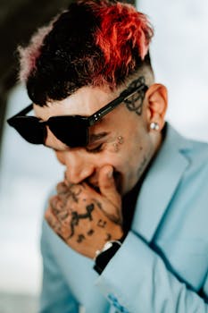 Portrait of a stylish young man with colorful hair, tattoos, and sunglasses in Buenos Aires.