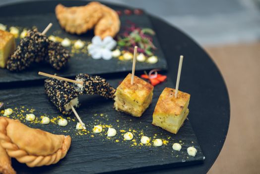 Savour Argentinian tapas with empanadas and fernet snacks beautifully presented on a slate platter. Ideal for outdoor brunching or evening drinks.