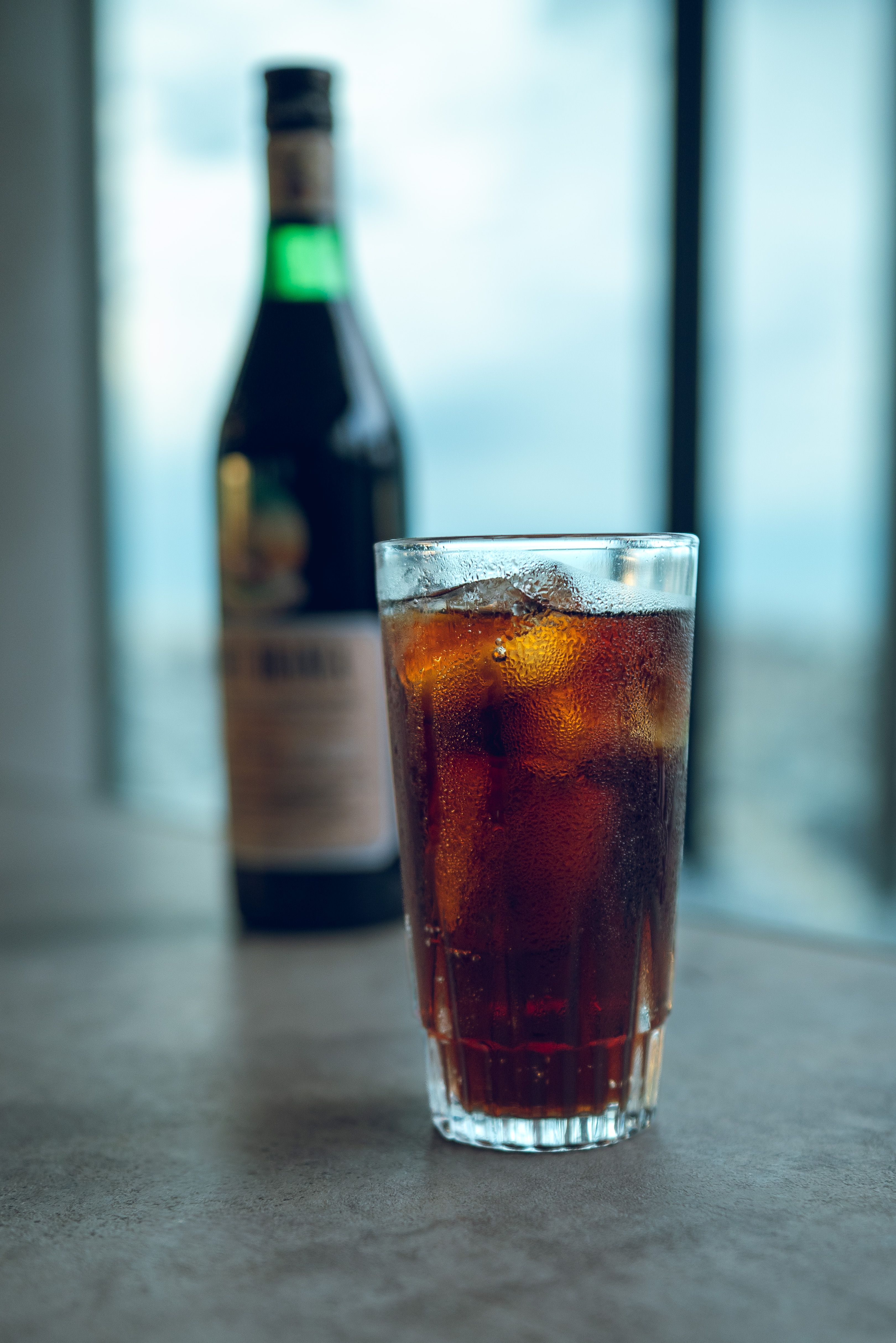 A close-up of a fernet cocktail with ice served at a Buenos Aires cafe terrace.
