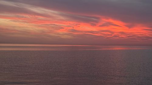 Free Breathtaking sunset with vivid colors reflecting on the calm ocean surface. Stock Photo