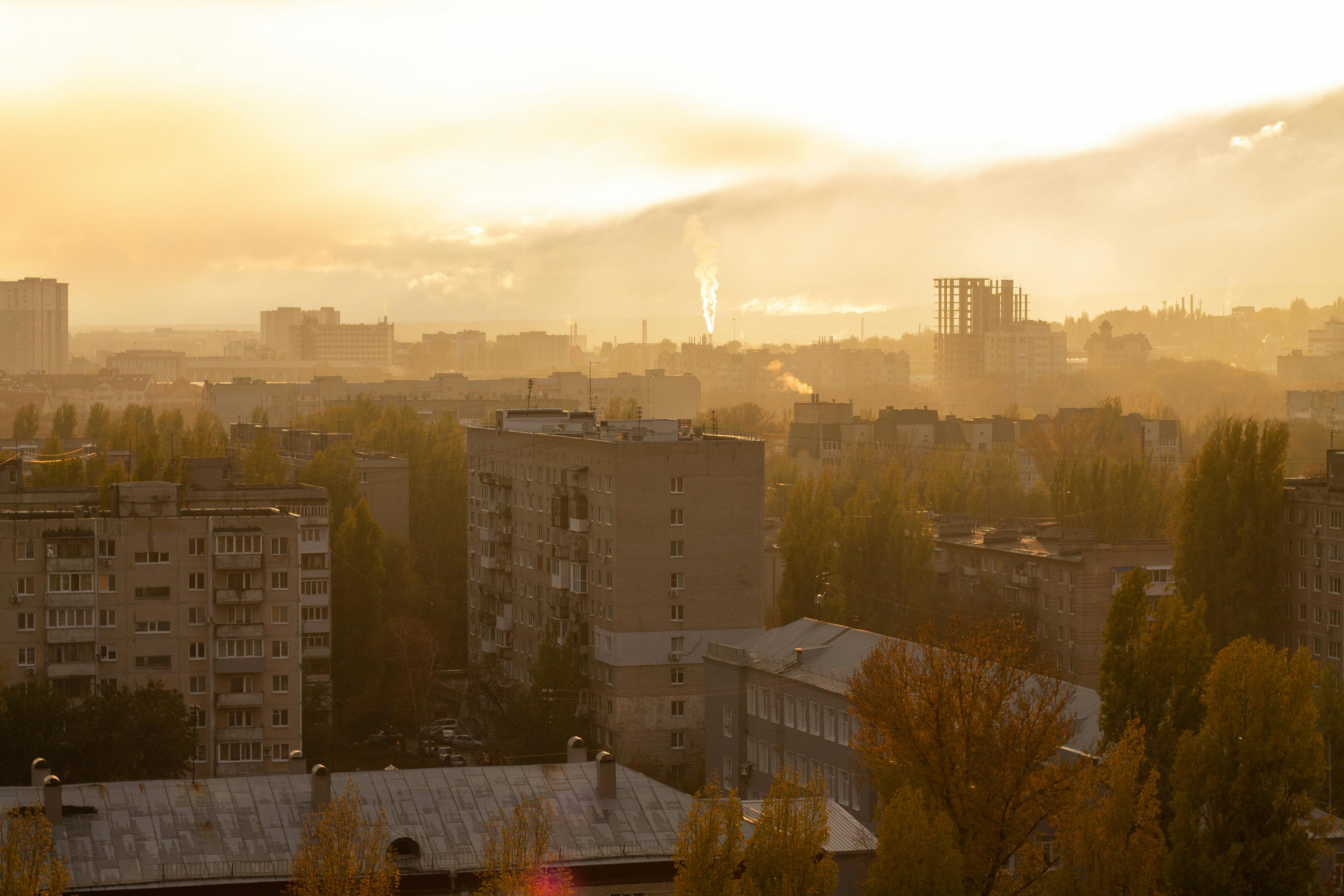 A scenic view of Saratov, Russia, during sunset with urban buildings and a golden sky.