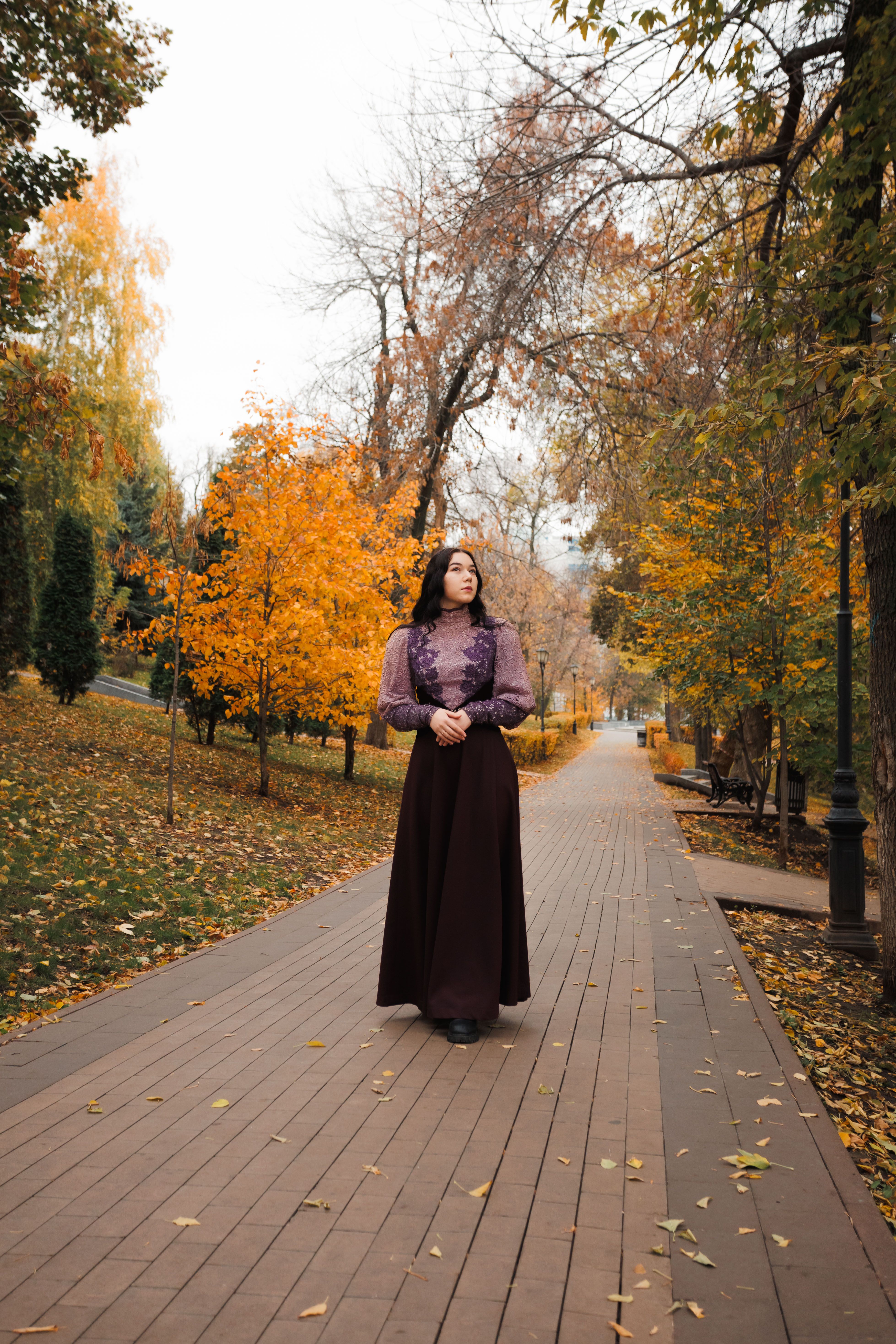 Woman Strolling Through Autumn Park Pathway · Free Stock Photo