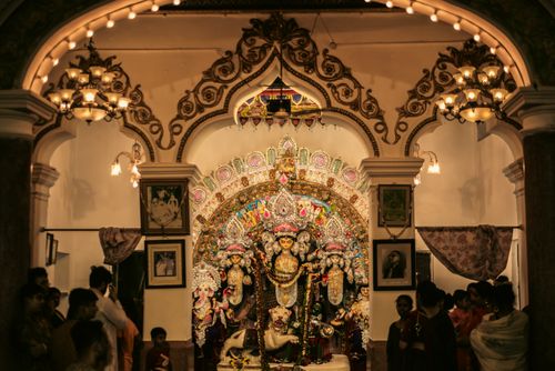 Free Devotees gather in a beautifully adorned Hindu temple to worship intricately decorated idols during a religious ceremony. Stock Photo