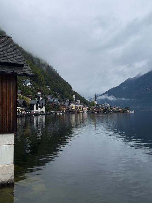 Free Picturesque view of Hallstatt village by the lake with misty mountains in the background. Stock Photo