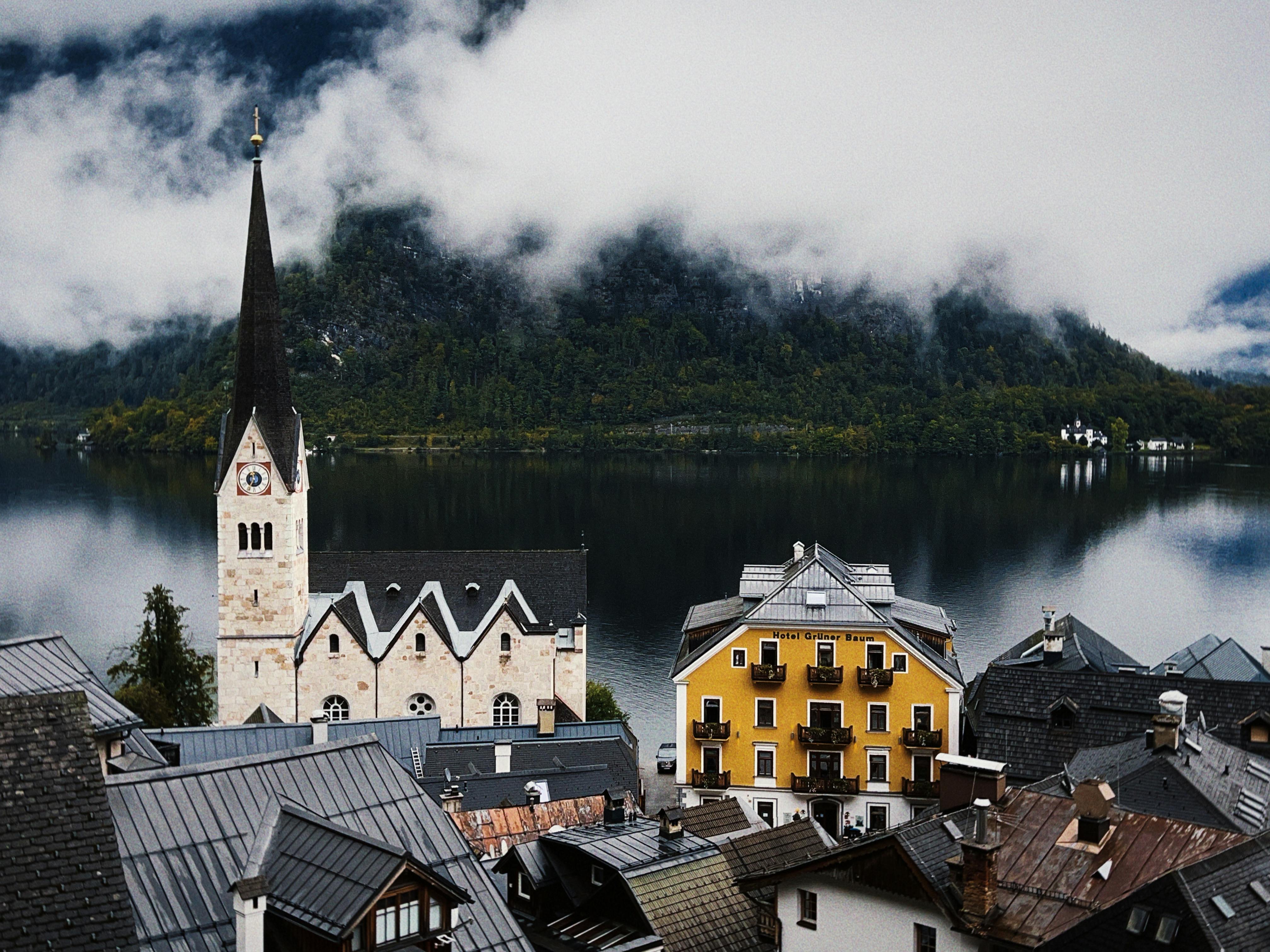 A picturesque view of Hallstatt's iconic church spire and colorful buildings by a serene lake.