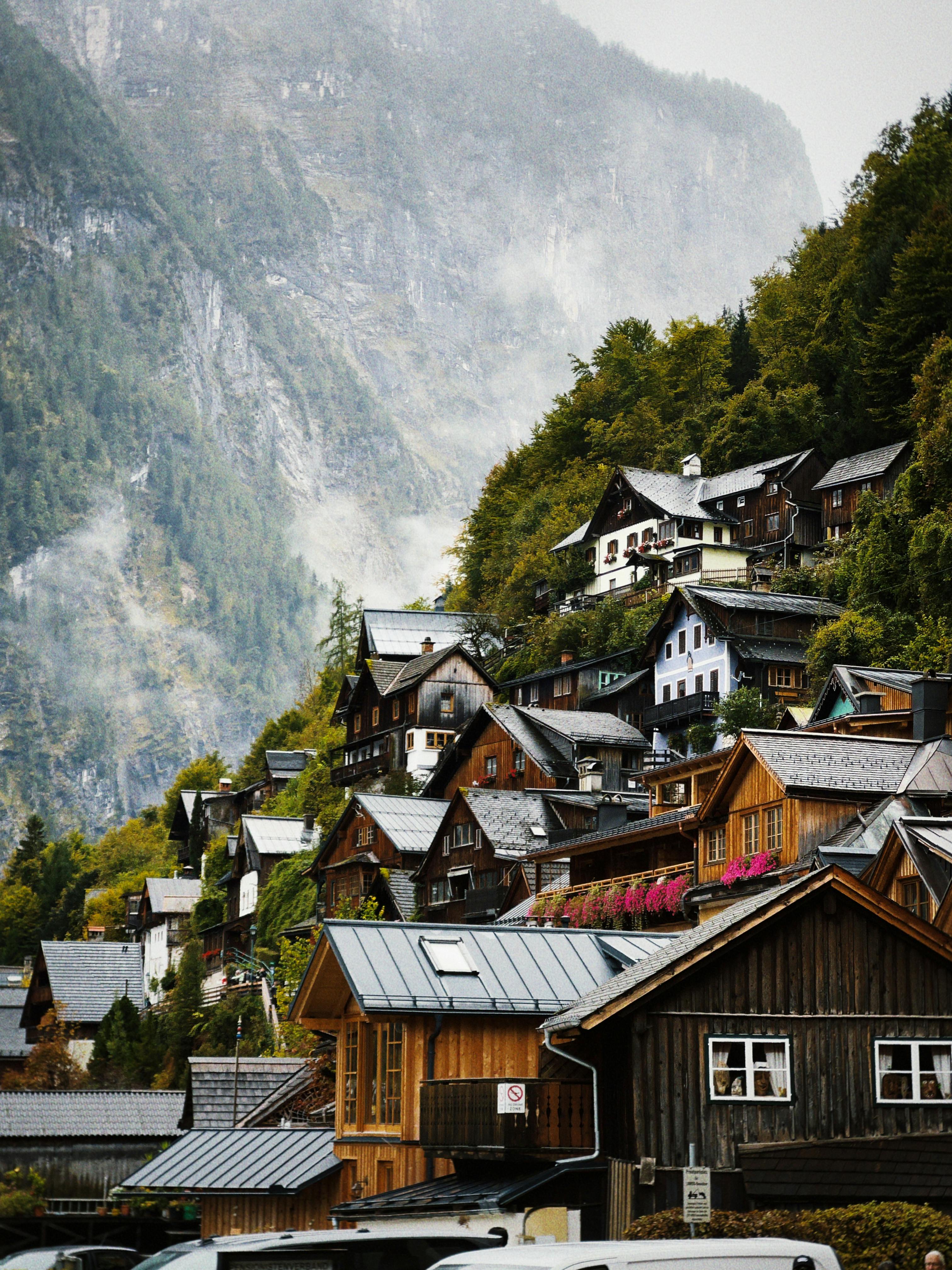 Picturesque mountain village nestled in lush foliage with traditional wooden houses, ideal for autumn travel.