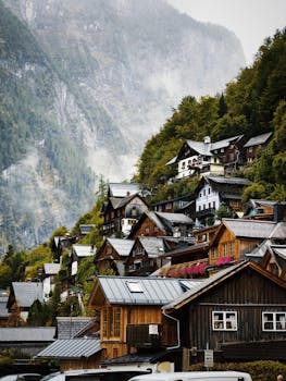 Picturesque mountain village nestled in lush foliage with traditional wooden houses, ideal for autumn travel.