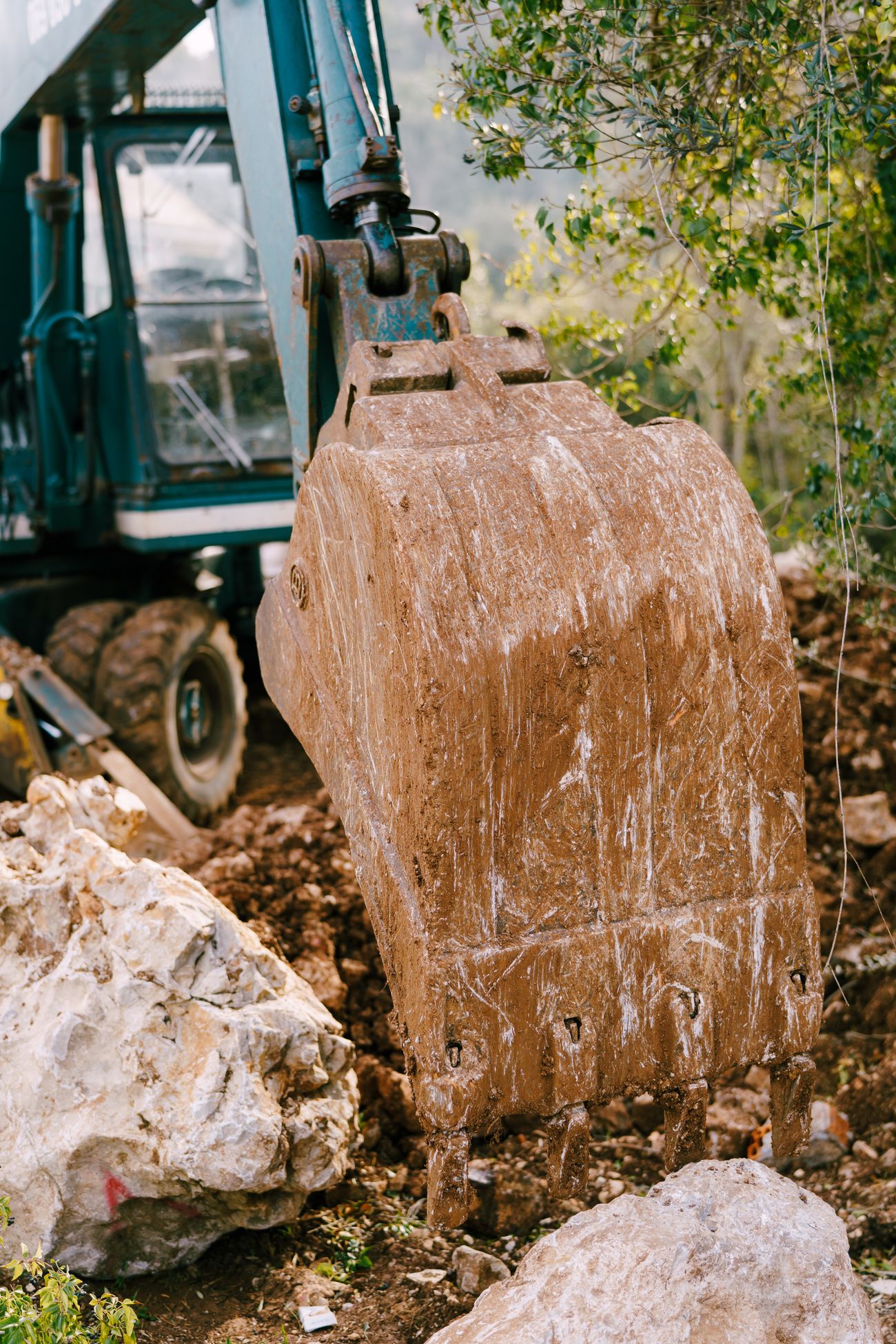 Excavator bucket working through soil and rock