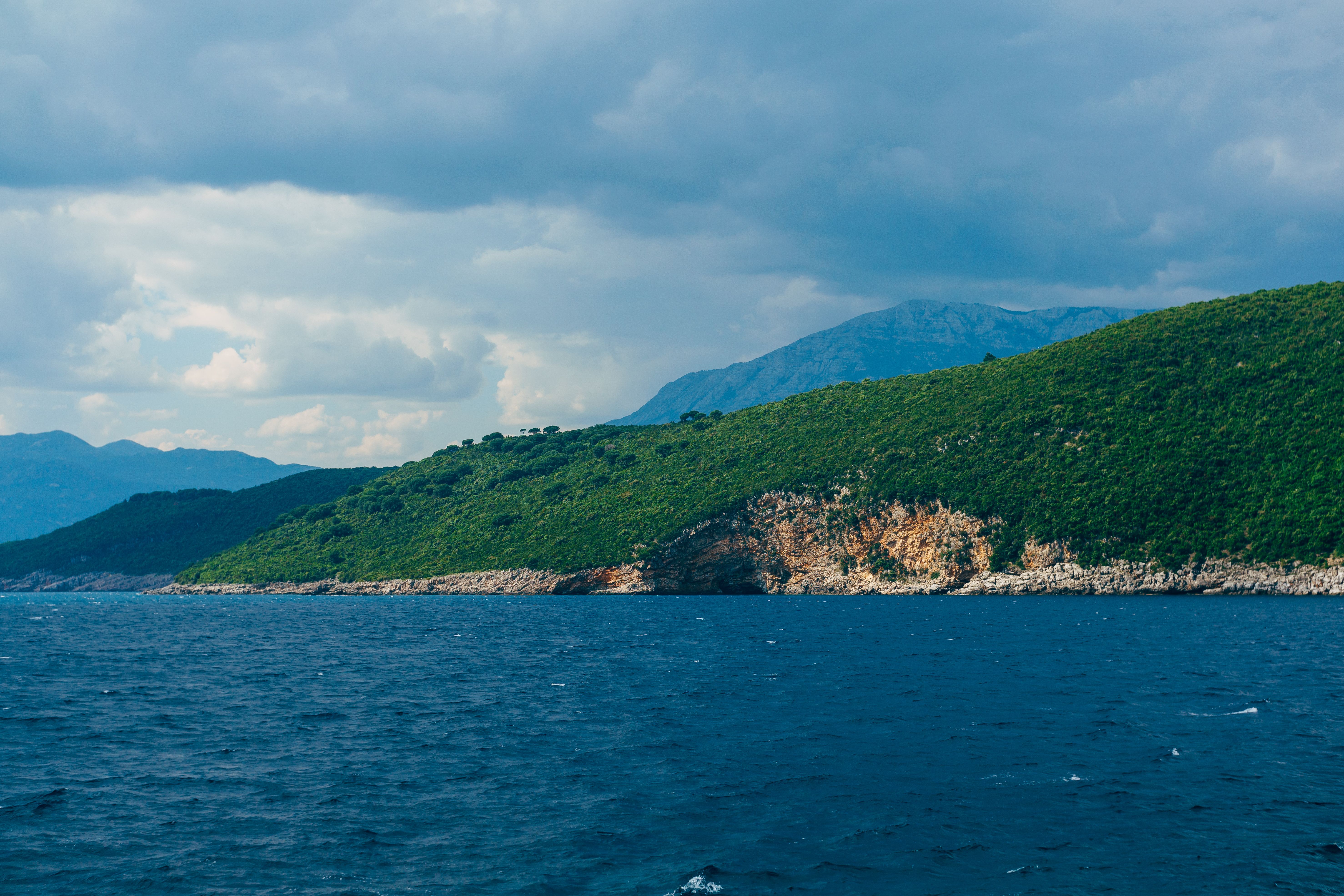 Scenic Coastal View with Lush Green Hills · Free Stock Photo