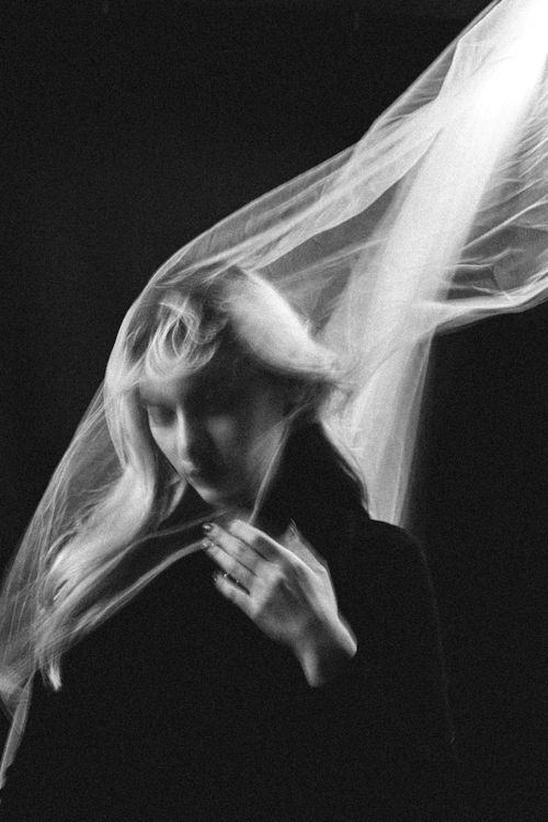 Free Black and white portrait of a woman with flowing veil and motion blur, creating a mysterious atmosphere. Stock Photo