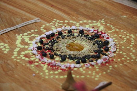 Colorful mandala with seeds and powders for Nepalese festive rituals symbolizing cultural richness.