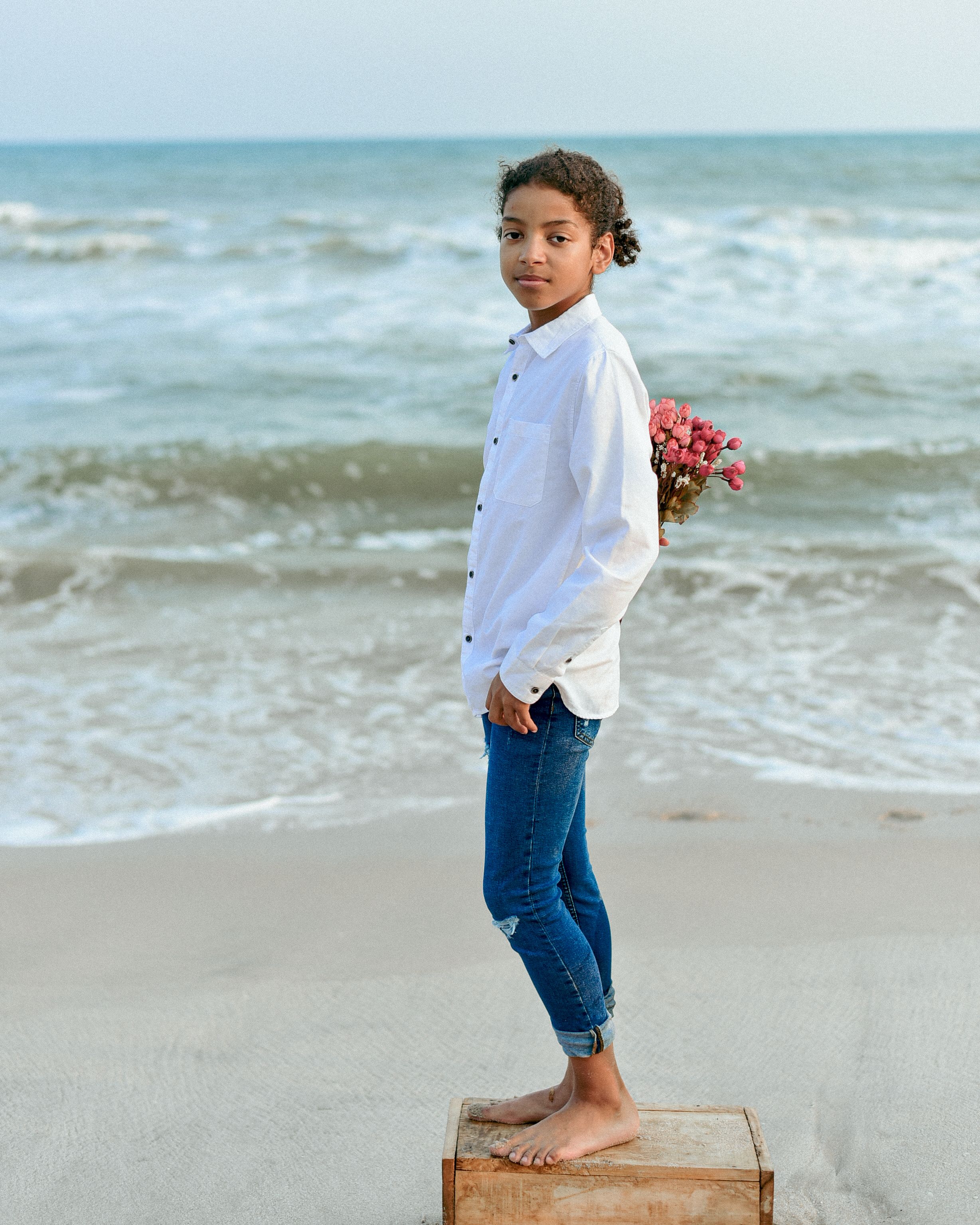 Young Girl with Flowers by the Sea Shore · Free Stock Photo