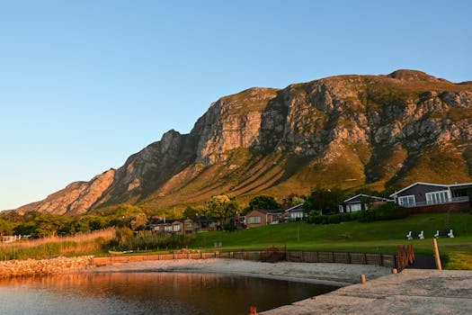 Sunset view of mountains and lagoon in Hermanus, South Africa, highlighting serene natural beauty.