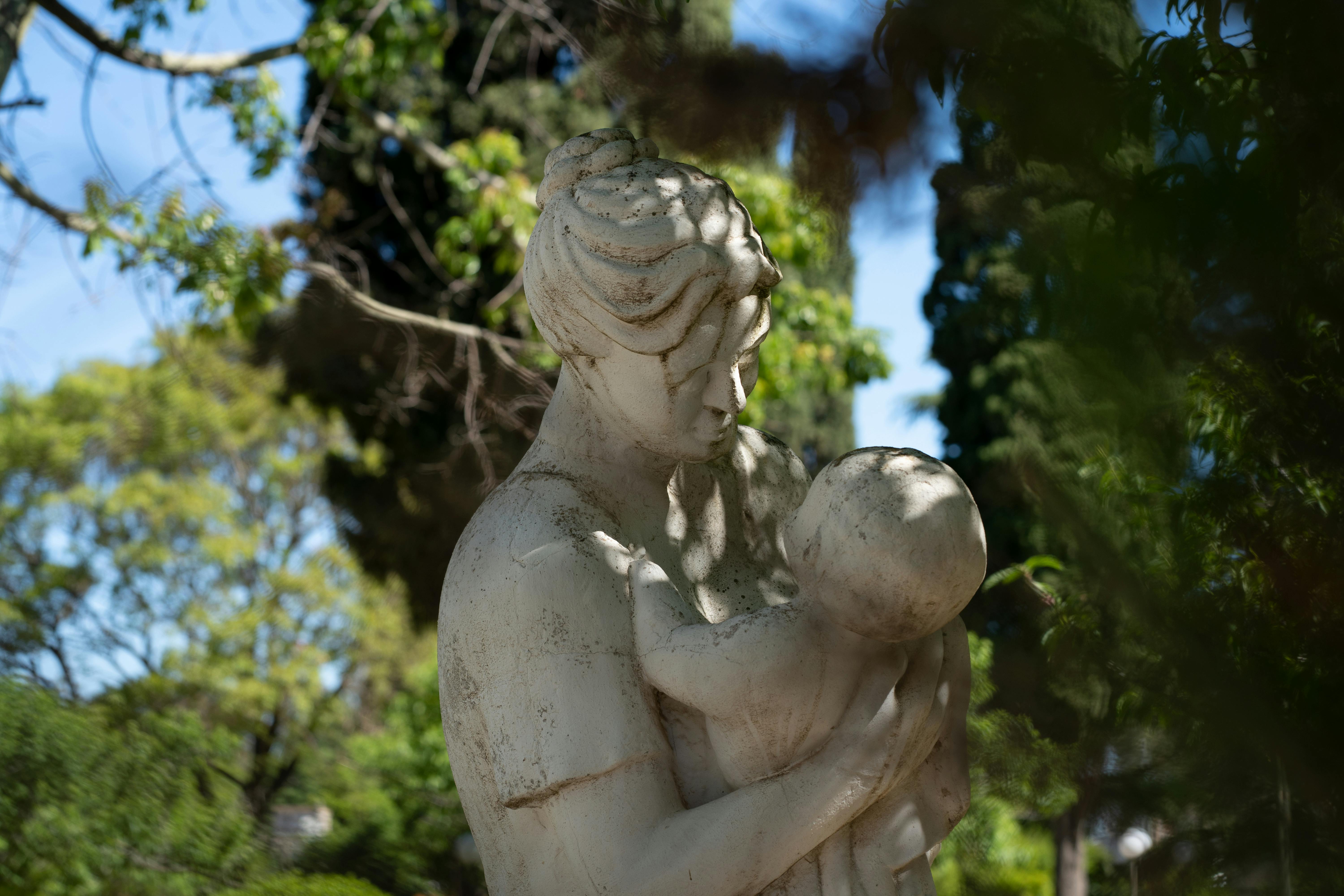 Gratuit Une statue sereine représentant une mère et son enfant, entourée de verdure, à Morrison, en Argentine. Photos