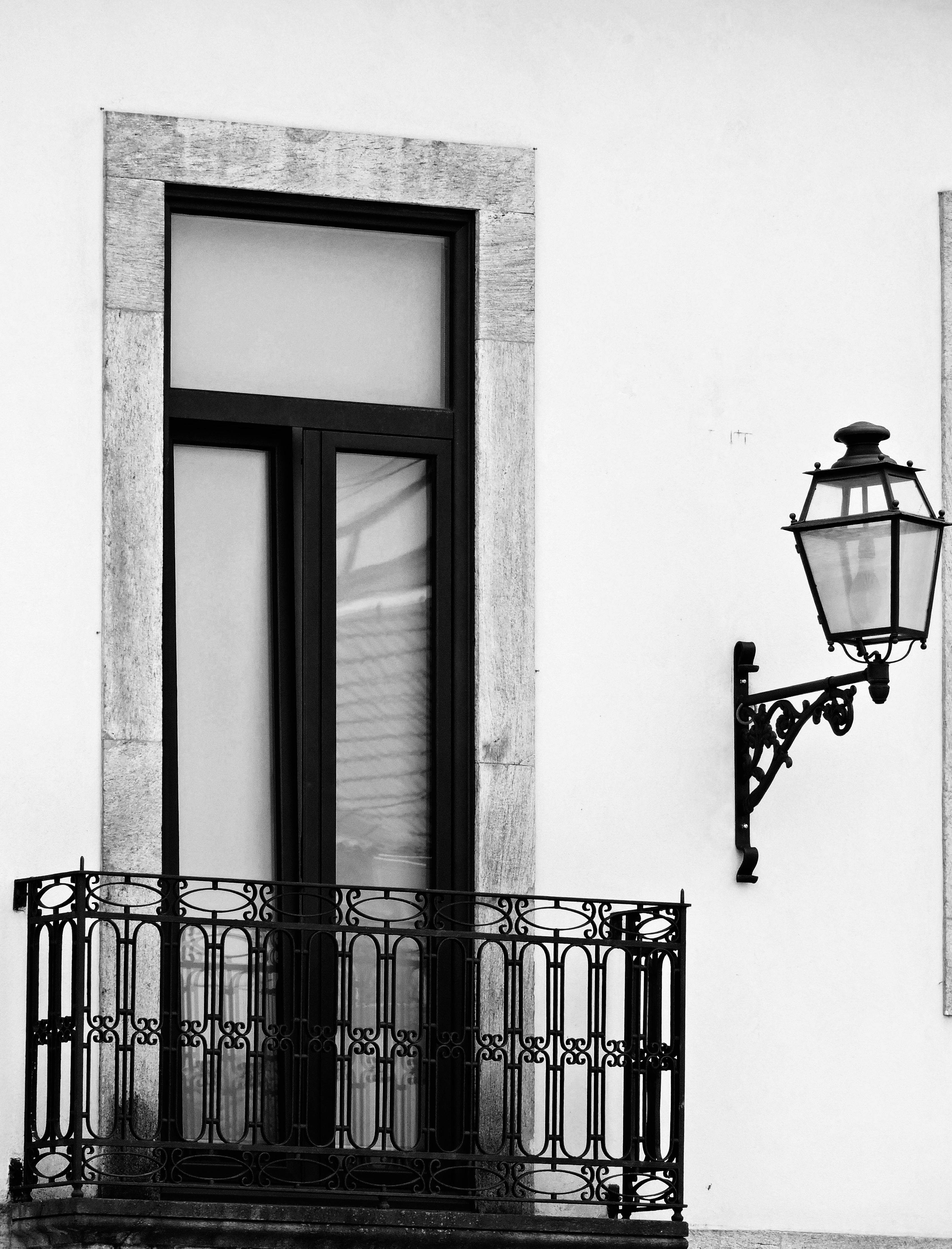 Gratuit Balcon și felinar vintage elegant, în alb și negru, care evidențiază farmecul arhitectural clasic. Fotografie de stoc