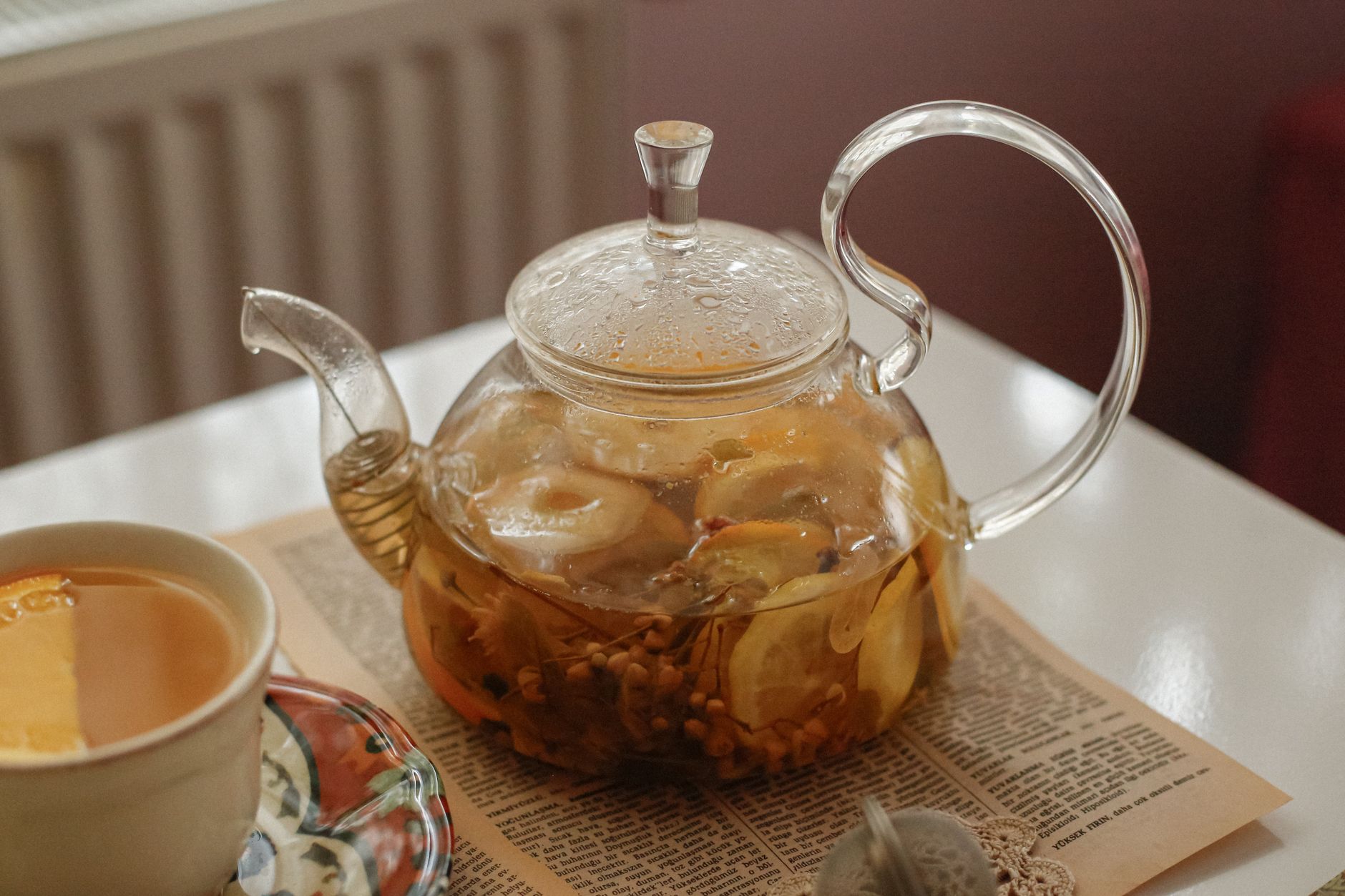 A warm, cozy scene with a glass teapot of herbal tea next to a cup, perfect for relaxation.