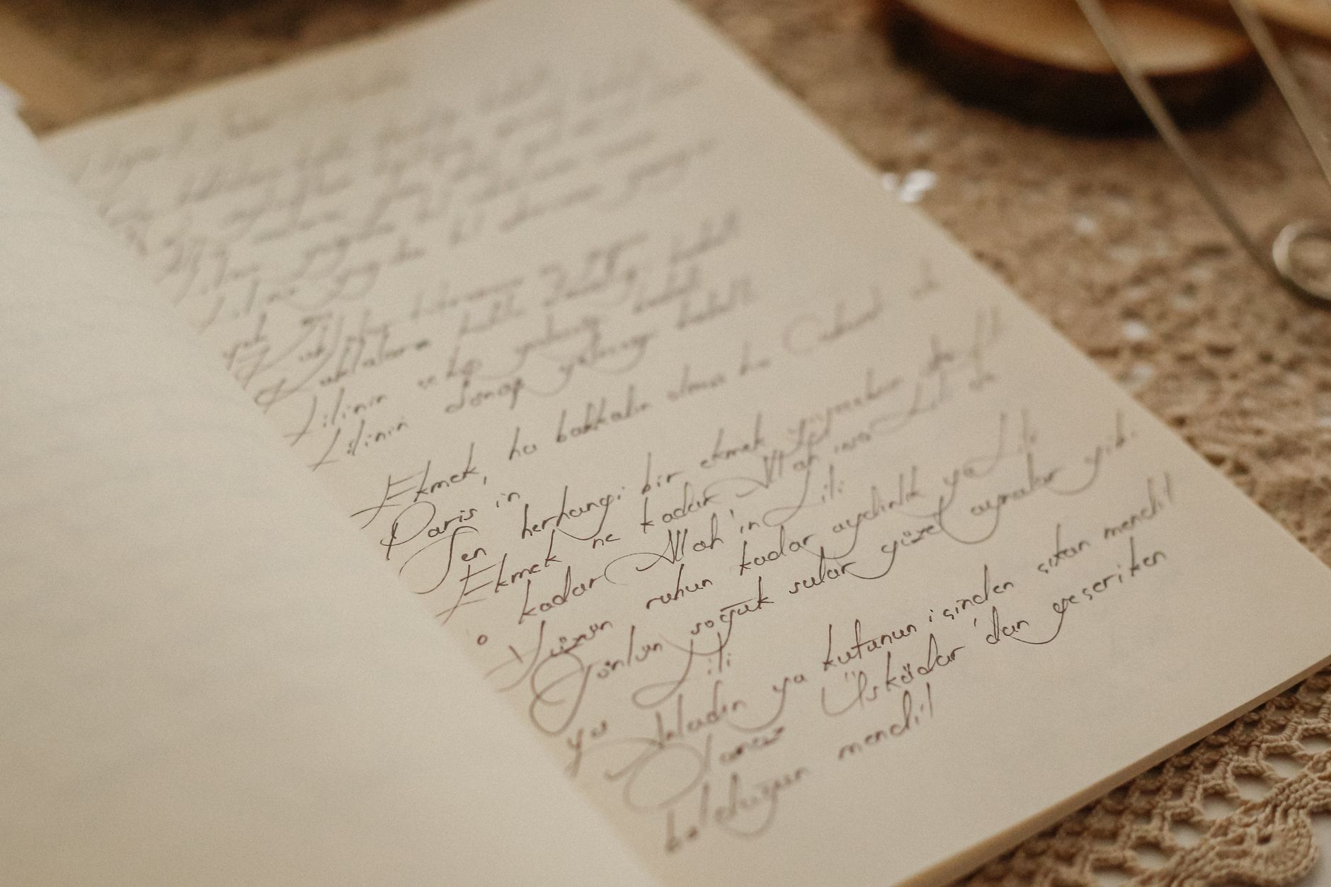 Beautiful handwritten text in calligraphy on an open page, placed on a crochet doily.