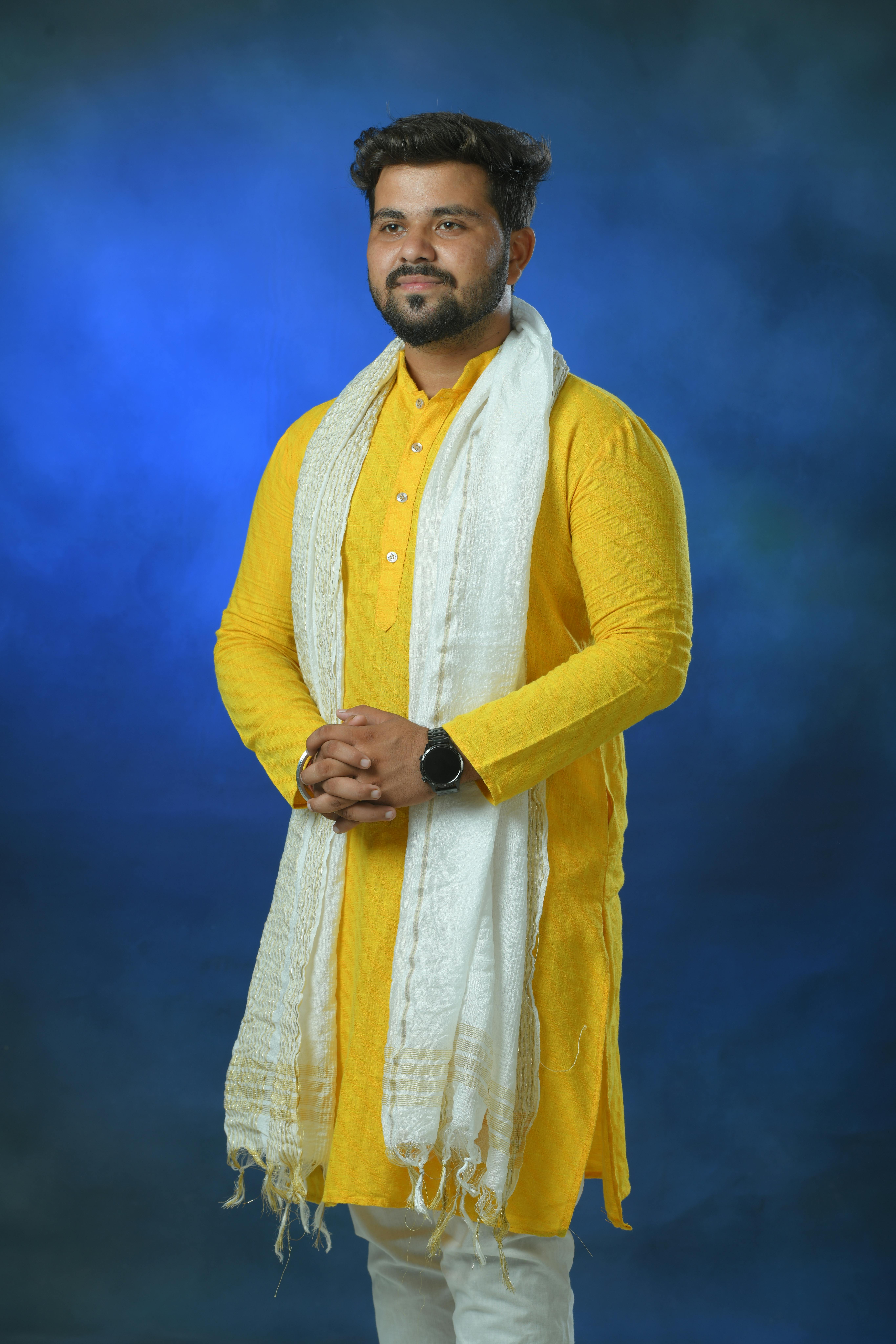 Elegant portrait of a man wearing a yellow kurta with traditional Indian styling.