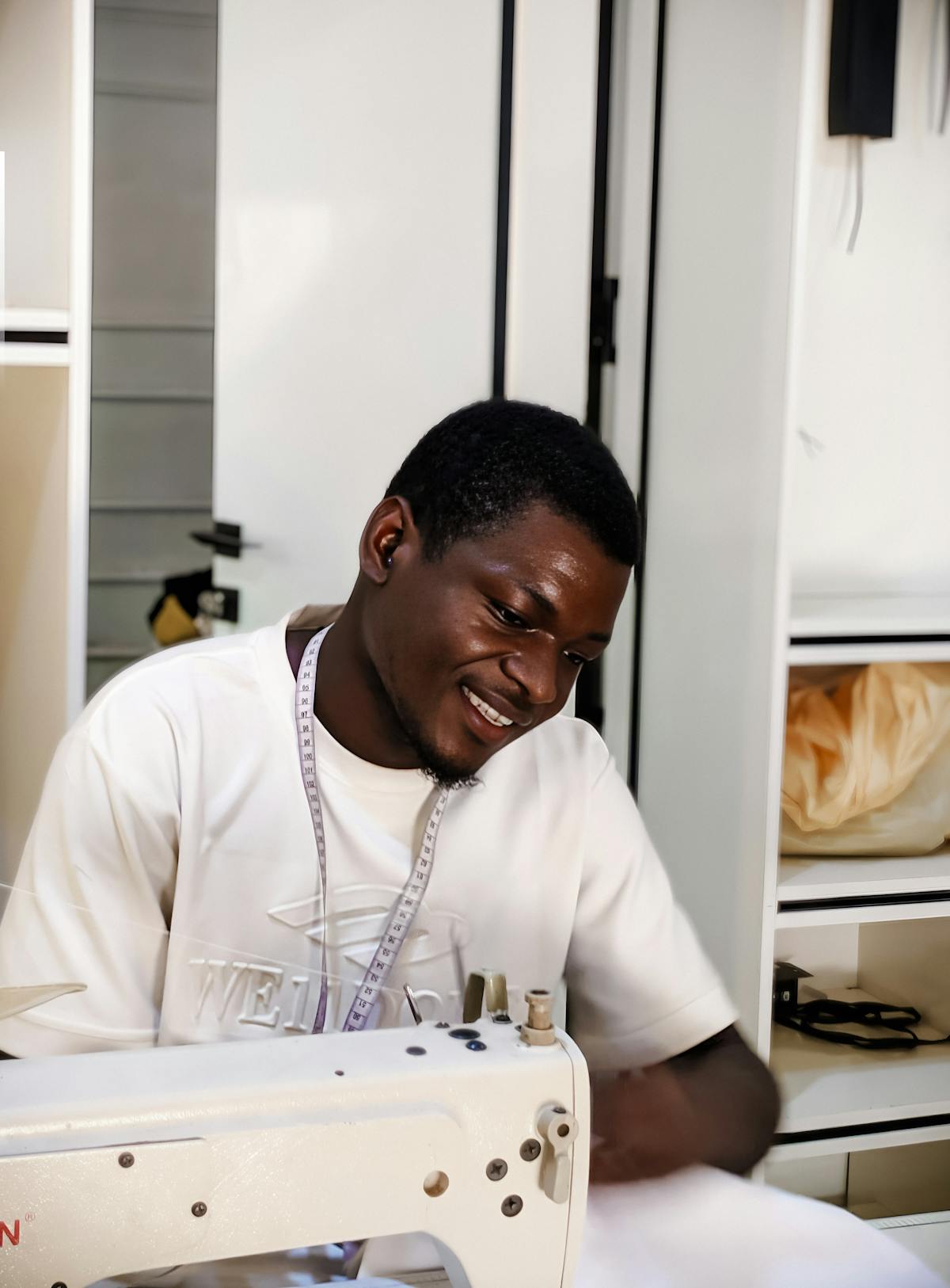 Sarto che misura capi con metro a nastro in laboratorio sartoriale