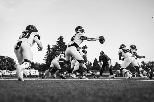 Free Energetic black and white image of football players practicing, highlighting teamwork and action. Stock Photo