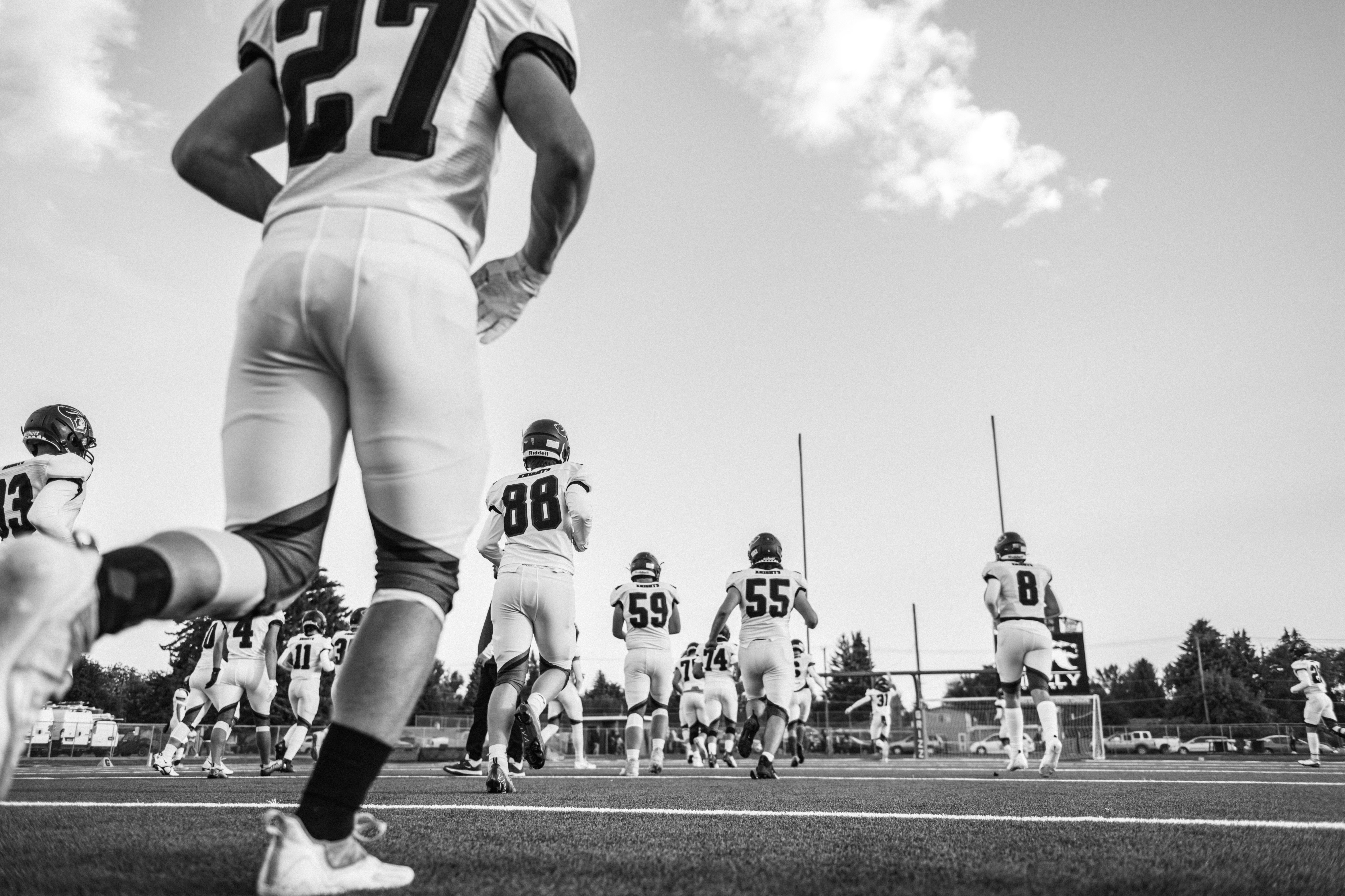 Person analyzing football statistics on a laptop with a pen and notebook.