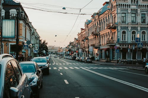 Bezpłatne Ludzie Chodzą Po ścieżce W Pobliżu Budynków I Różnych Pojazdów Na Drogach Zdjęcie z galerii