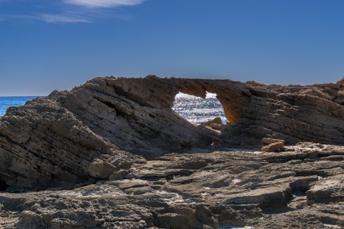Free Stunning coastal rock arch formation in Torrevieja, Spain, under clear blue skies. Stock Photo