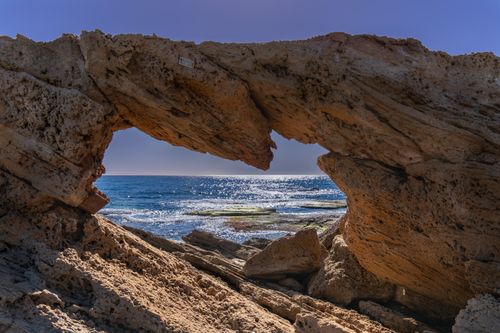 Free Natural rock arch frames the sparkling Mediterranean Sea along Torrevieja’s coastline. Stock Photo