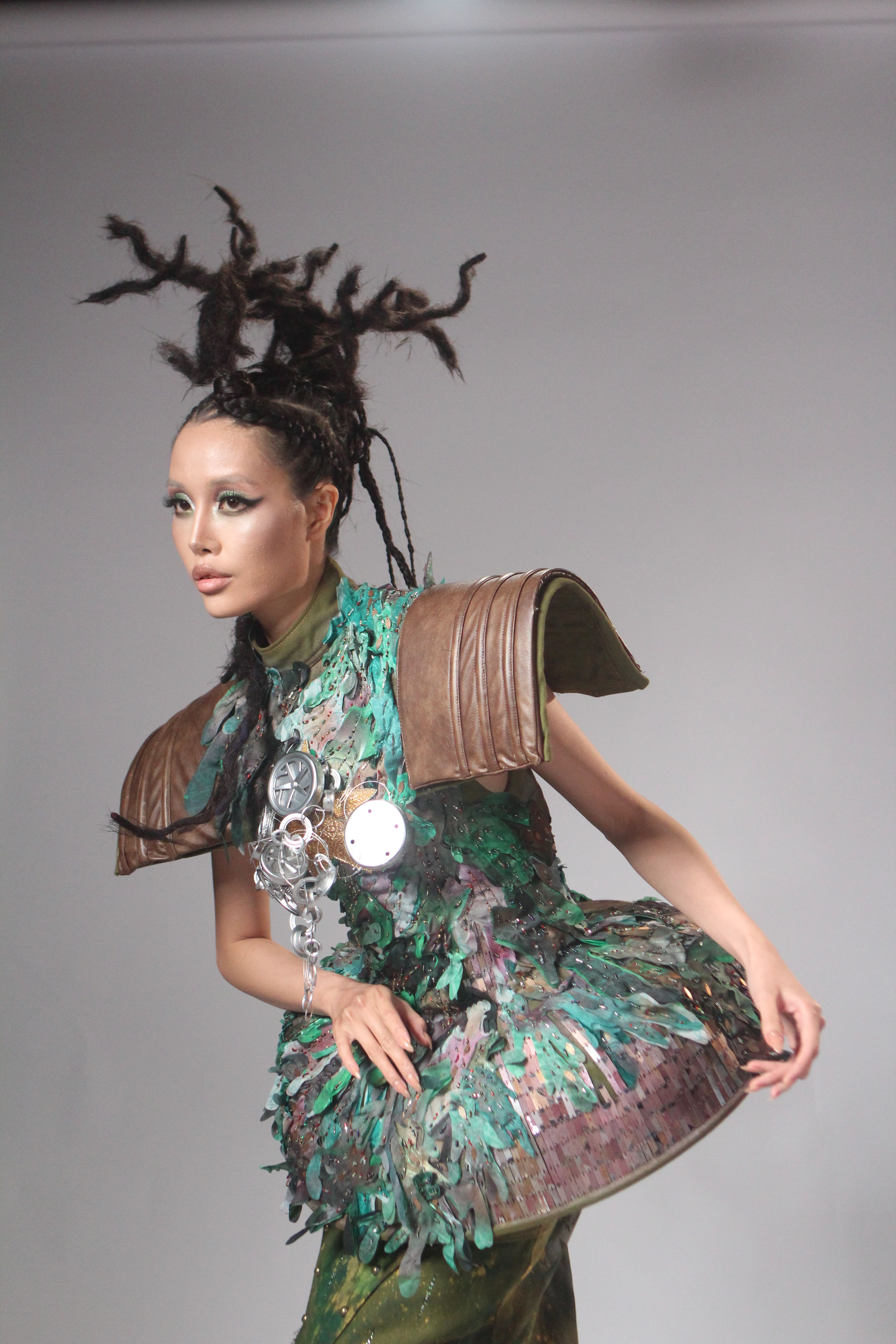 A striking portrait of a model in avant-garde fashion with a dramatic hairstyle.