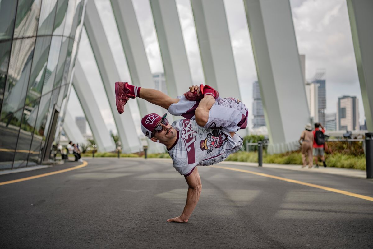 Breakdancer holding a controlled freeze in an urban setting