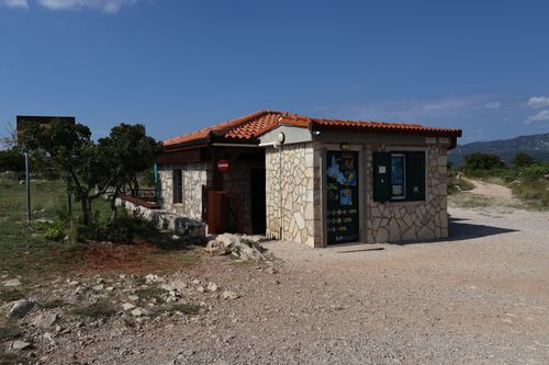 Free Rustic stone building with a red tile roof in a serene countryside setting. Stock Photo